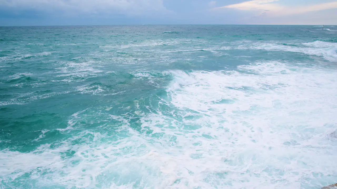 Sea waves breaking on underwater rock creating crest and crushing on rocky shore cardinal mark