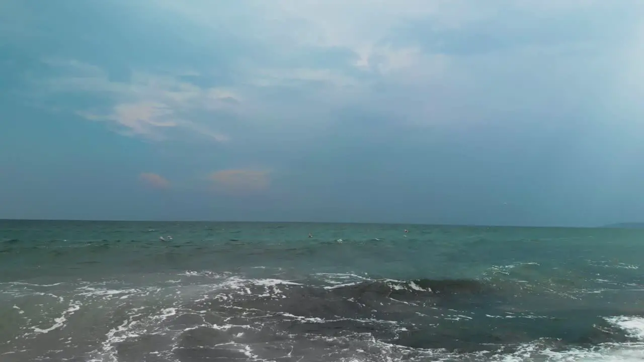 Panning shot of seagulls flying close to the sea water in cloudy summer day Sozopol Bulgaria