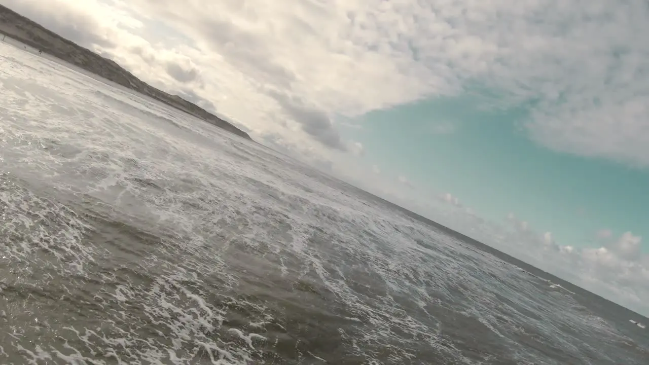 Low Aerial Towards Foamy Seascape At The Beach Of Texel Island In North Holland Netherlands