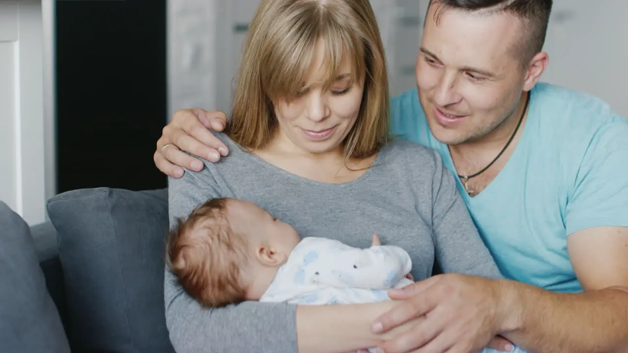 Portrait Of A Young Happy Family At Home Father Mother And Baby