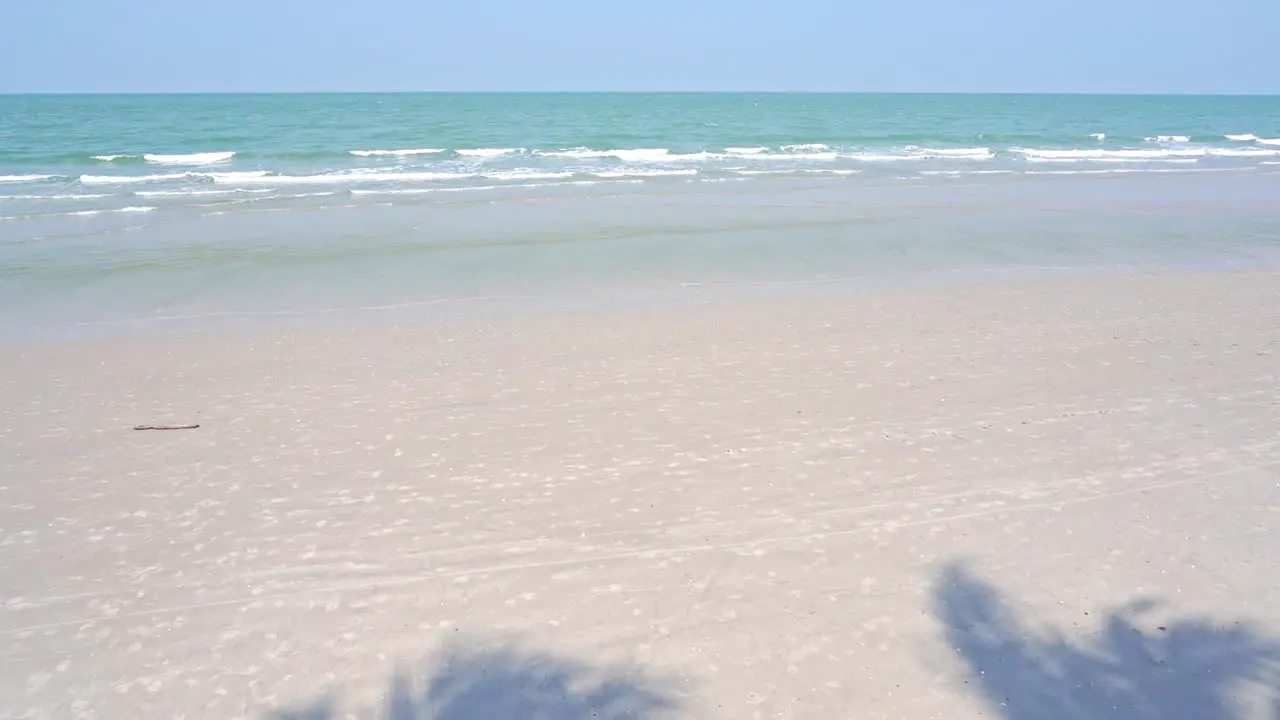 Slow motion of waves rolling up on a white sandy beach