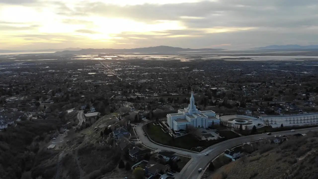 Drone flies over LDS temple toward sunset