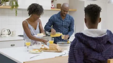 Young Boy Joins His Family at Kitchen Island During Breakfast 02