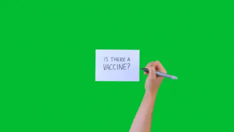 Woman Writing Is There a Vaccine on Paper with Green Screen