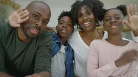 Joyful Family Talking and Waving Goodbye Directly into Webcam During Video Call