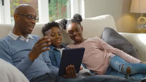 Grandfather Reading a Story to His Grandchildren from Electronic Tablet