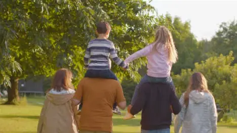 Tracking Shot of Children Sitting On Their Parents and Grandparents Shoulders 05