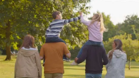 Tracking Shot of Children Sitting On Their Parents and Grandparents Shoulders 06