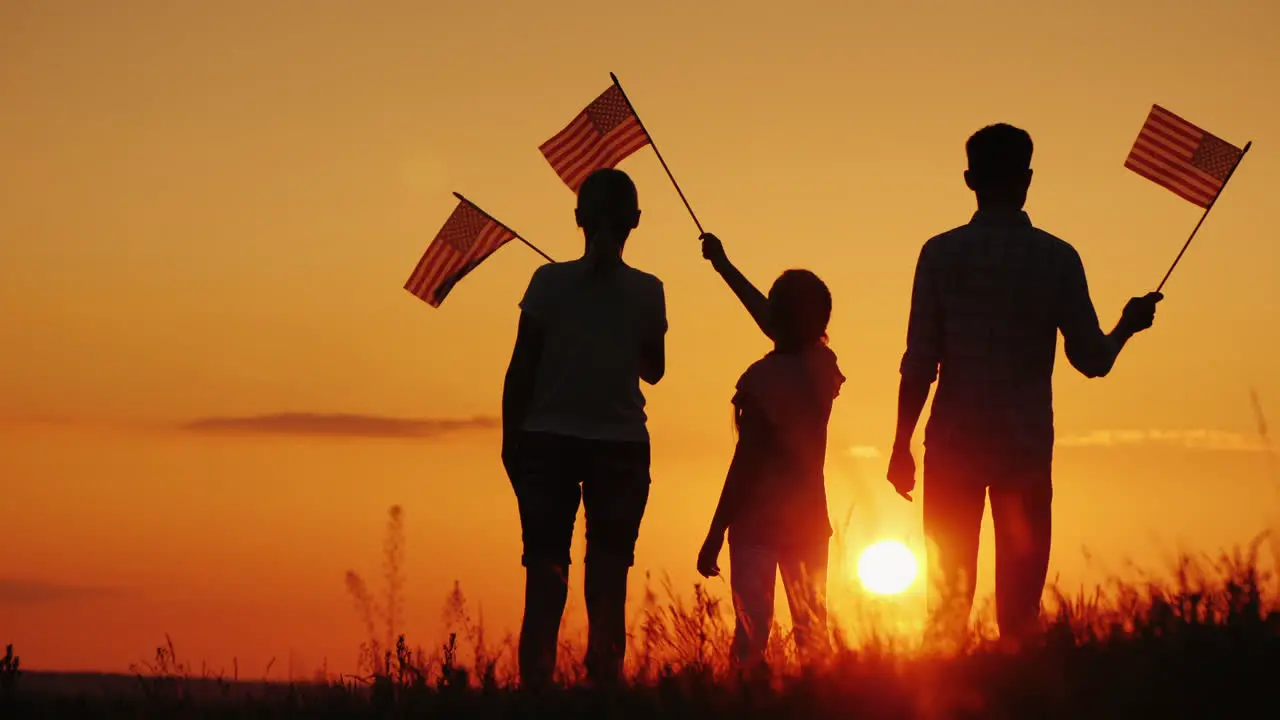 A Family With American Flags In Their Hands Meets The Dawn Independence Day Celebration