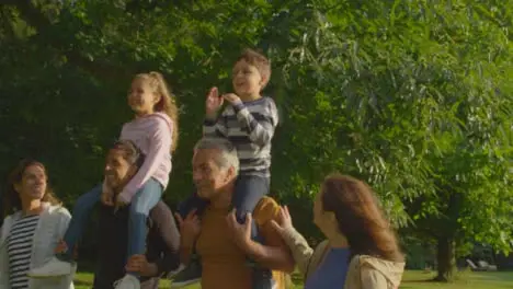 Tracking Shot of Children Riding On Their Family's Shoulders 01