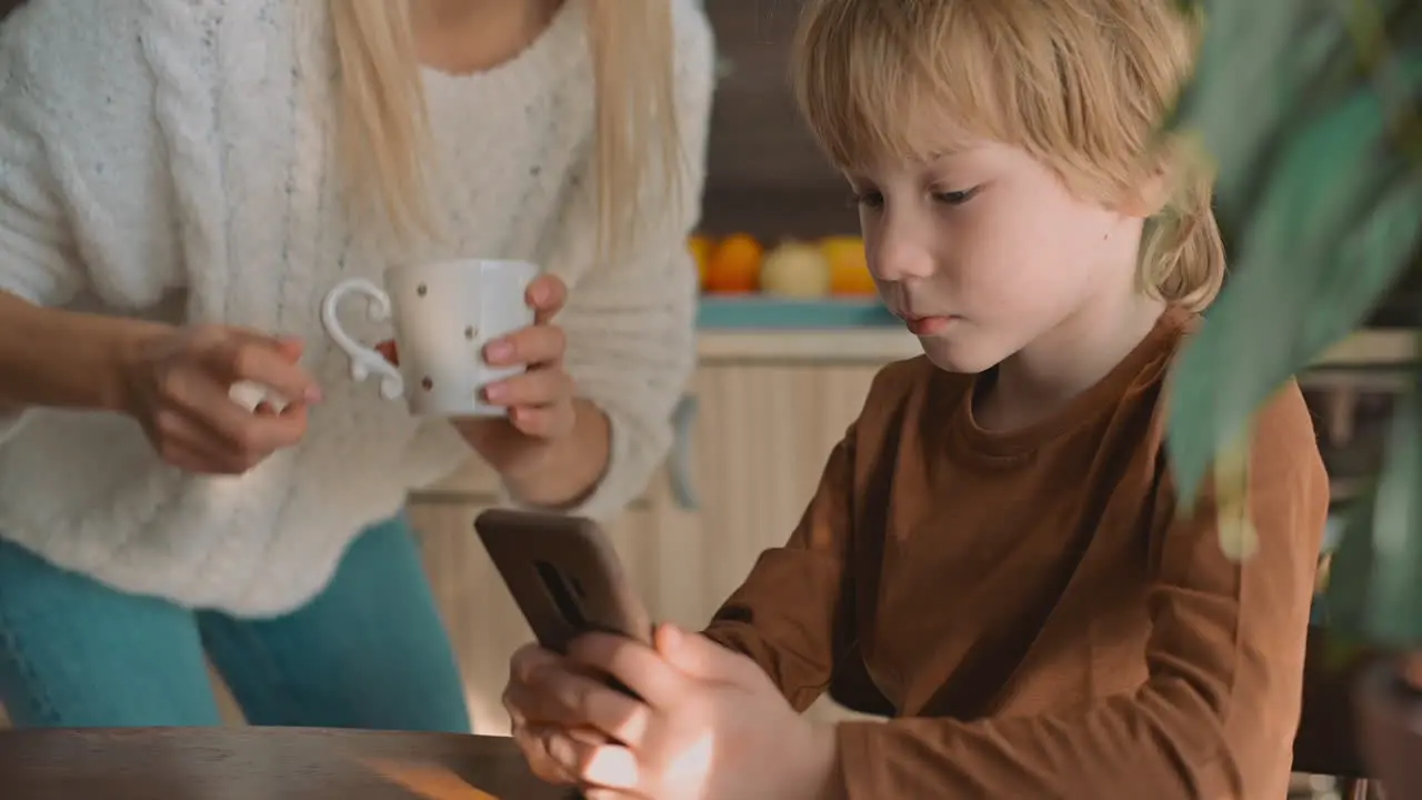 Niño Pequeño Y Madre Viendo El Teléfono Inteligente Y Usando Una Aplicación En Casa