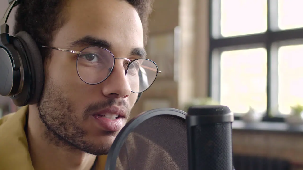 Vista De Cerca Del Hombre Grabando Un Podcast Usando Anteojos Y Auriculares Y Hablando En Un Micrófono 1