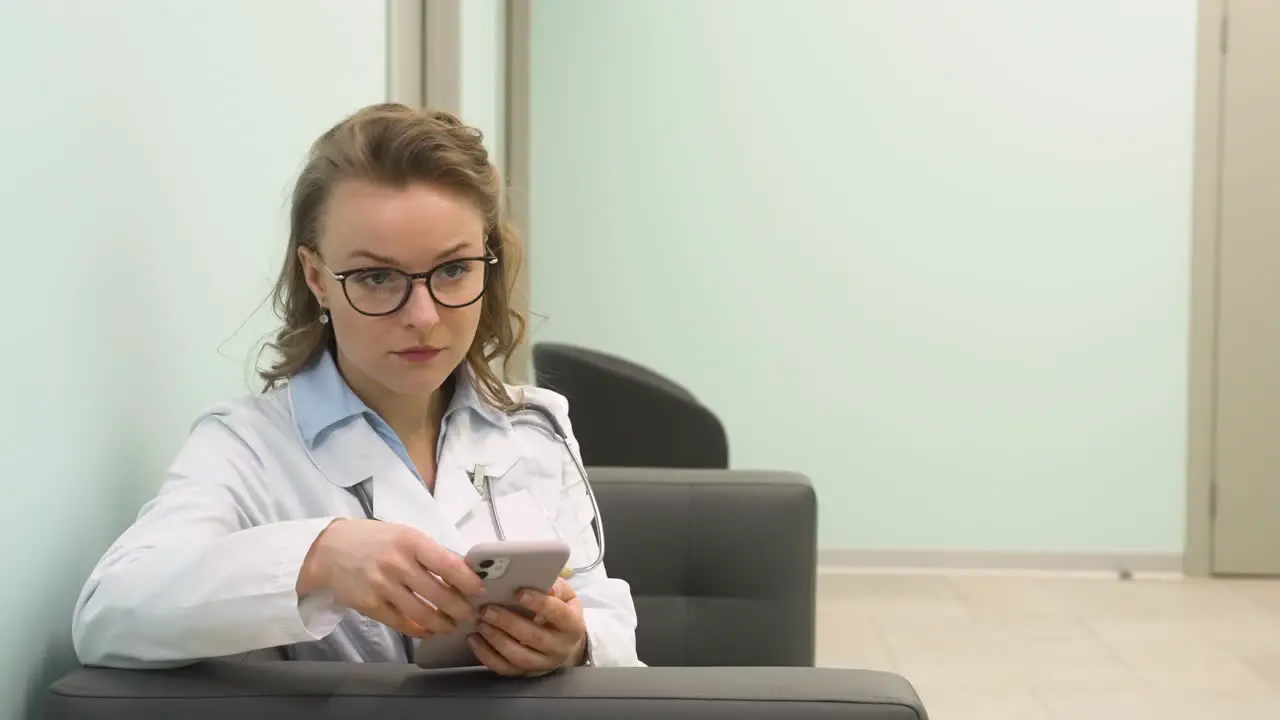 Pretty Female Doctor Using Mobile Phone At Clinic