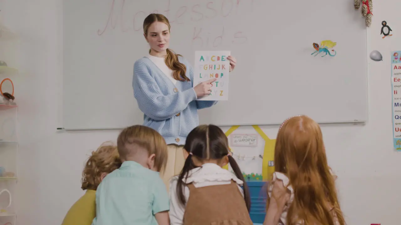 Female Teacher Teaching Letters Of The Alphabet To Her Pupils In A Montessori School 1