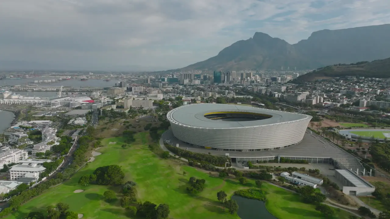 Forwards fly above golf course at Green Point Stadium Modern football arena in city Mountains in background Cape Town South Africa