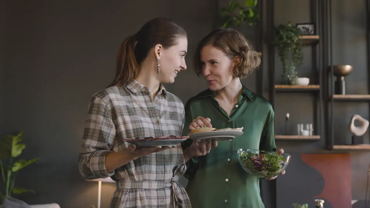 Two Happy Women Talking About Food And Laughing Together At Home