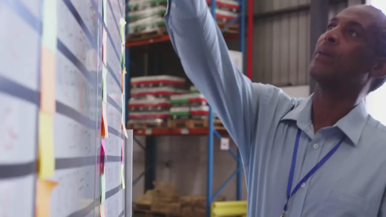 Close of man writing on clipboard in warehouse 4k