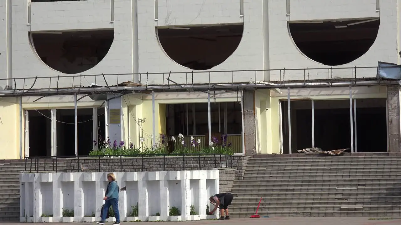 Establishing Shot Of The Badly Damaged Borodyanka Palace Of Culture With Volunteers Cleaning Up The Damage Outside