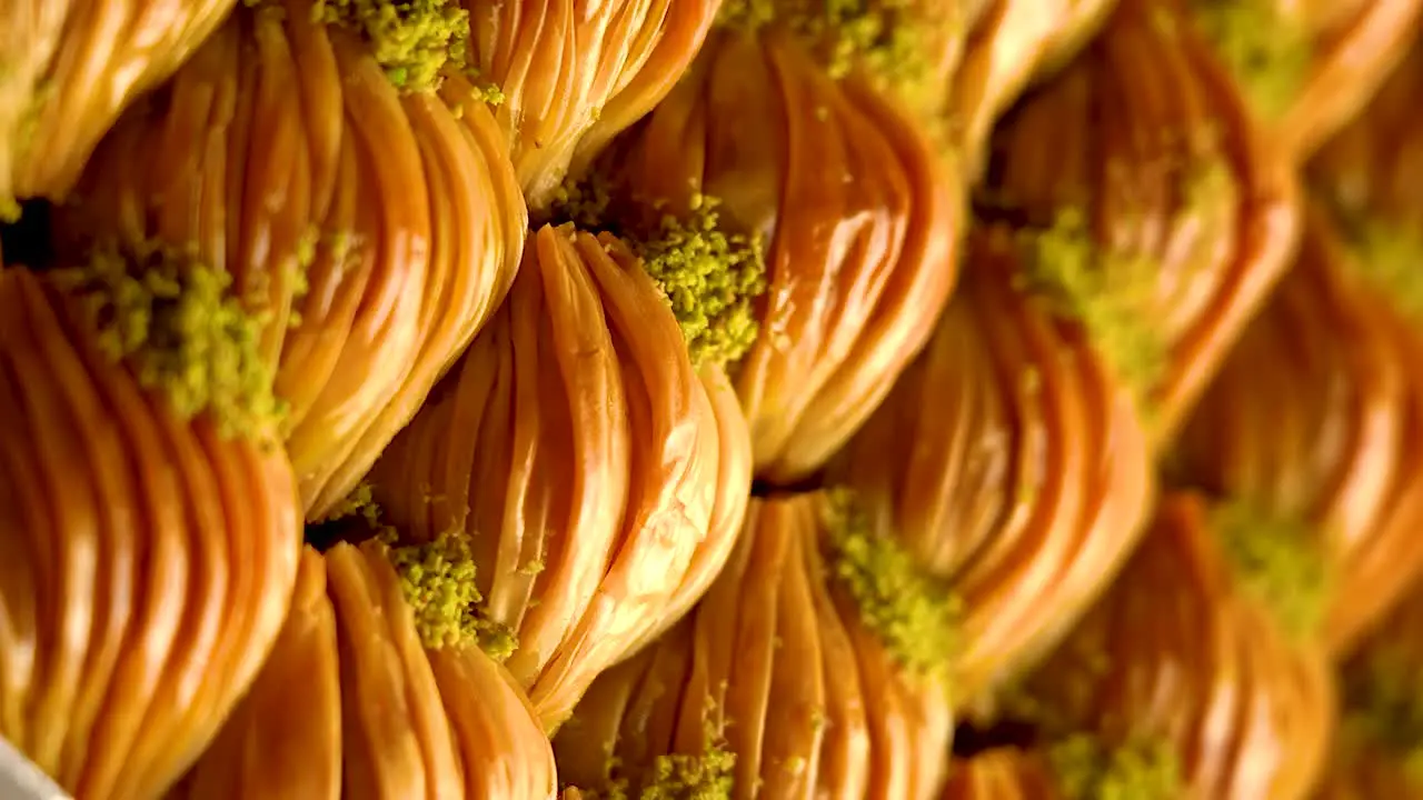 A tray of pieces of Turkish baklava sweets with pistachios  slow motion video vertical video