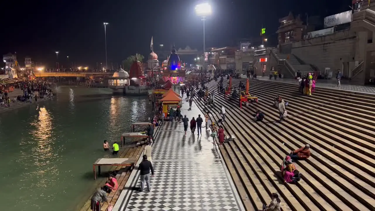 pov shot Many people are coming to sit near the river Ganga after visiting the temple