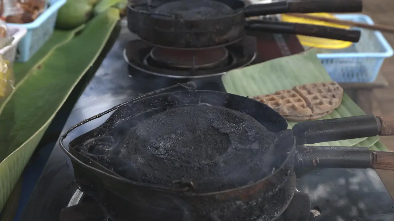 Street food vendor is preparing Thai style waffle a kind of ancient Thai dessert-snack made of rice flour coconut milk etc