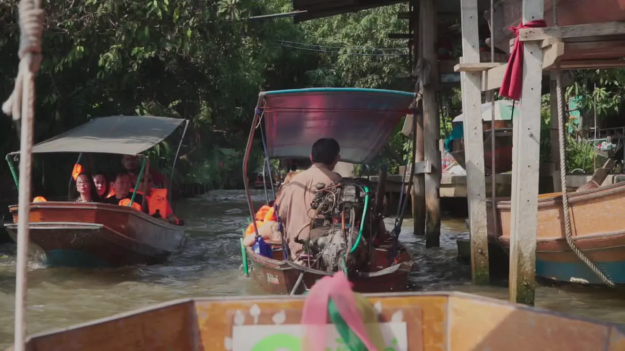 Medium shot inside a moving pump boat tourist on a pump boat approaching in the Thailand Floating Market