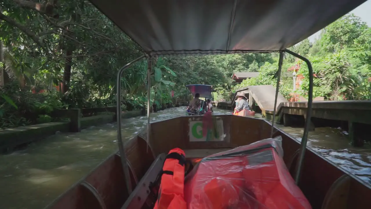 Panning Right Shot Moving forward inside a pump boat Wooden Boat when under the bridge in Thailand Floating Market