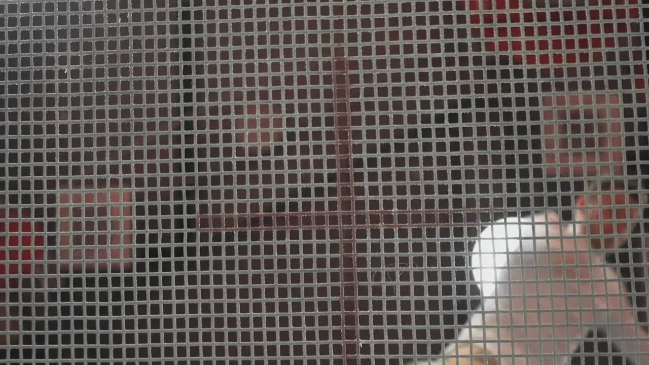 Man in white clothes jumping on a trampoline bottom view through the net