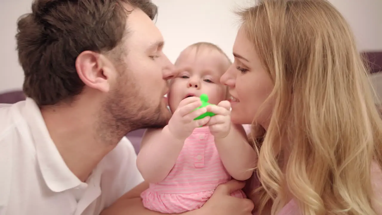 Beautiful family with baby Sweet family love Mom and dad kissing child girl