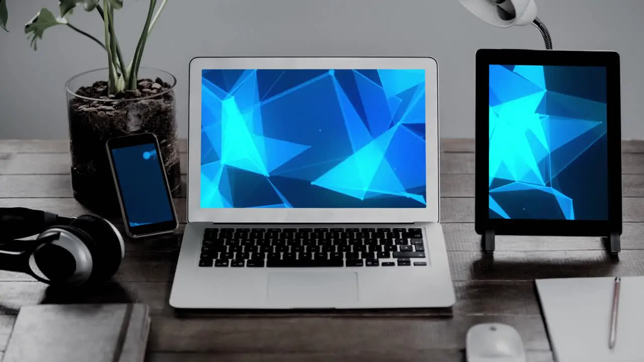 Animation of technological devices with blue shapes on screen on desk