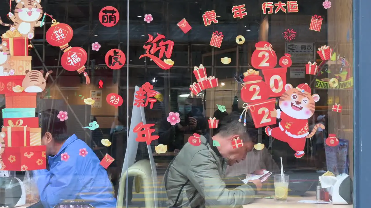 Customers eat at a restaurant decorated with numerous Chinese New Year theme stickers ahead of the upcoming Lunar Chinese New Year