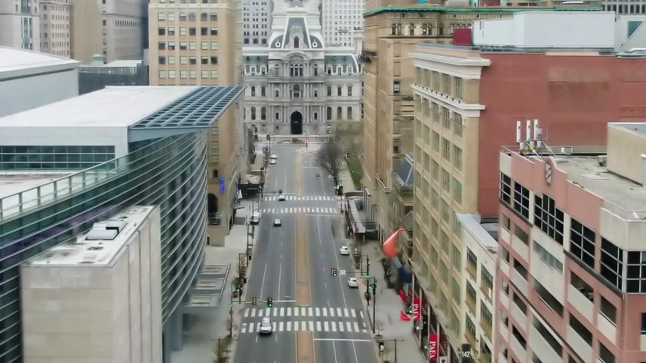 Aerial view overlooking a quiet street in Philadelphia City Hall in the background reverse drone shot