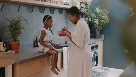 Black family mother and girl feeding