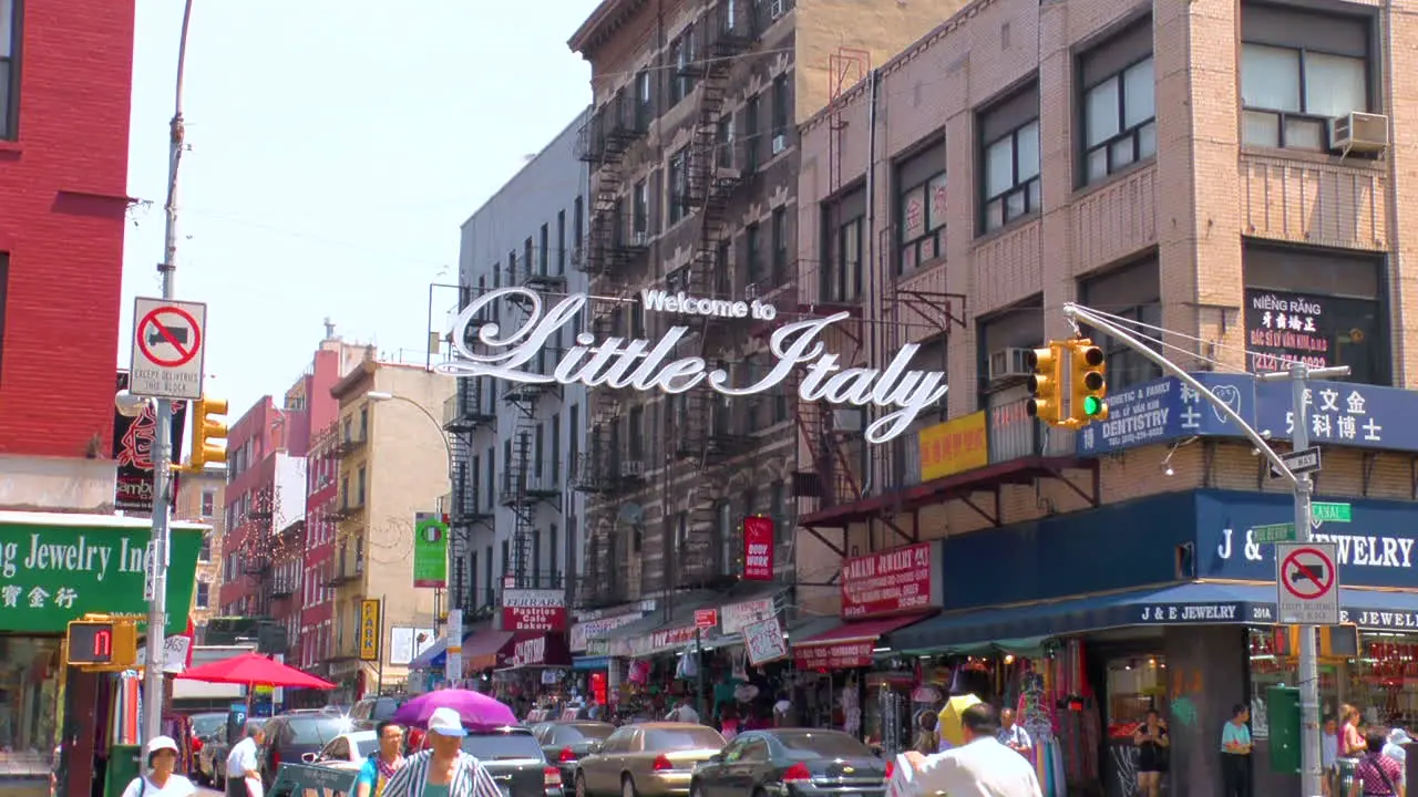 Timelapse Street scene in Little Italy Manhattan people walking and crossing roads with traffic and Little Italy sign