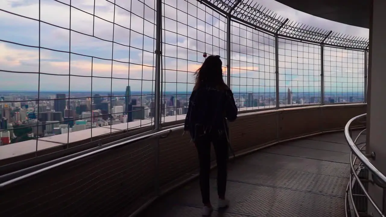 A girl walks on the rooftop of the Baiyoke tower in Bangkok