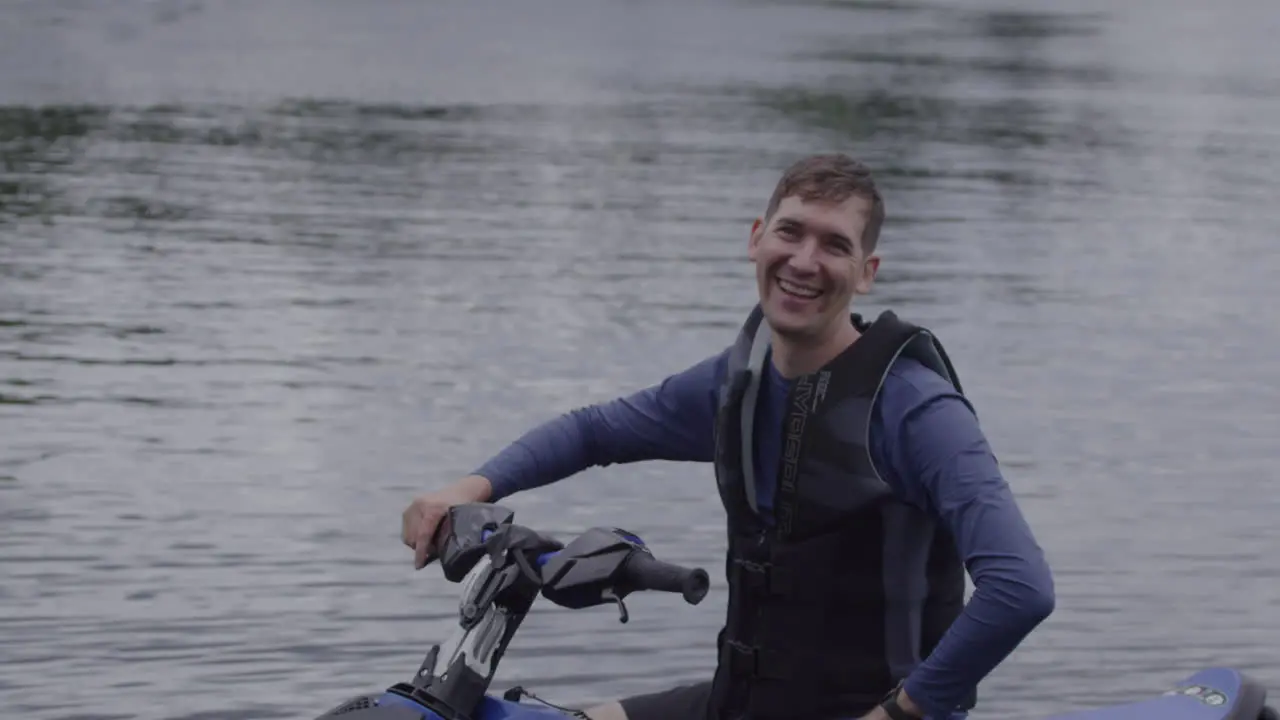 Dad waving and smiling on a jet ski