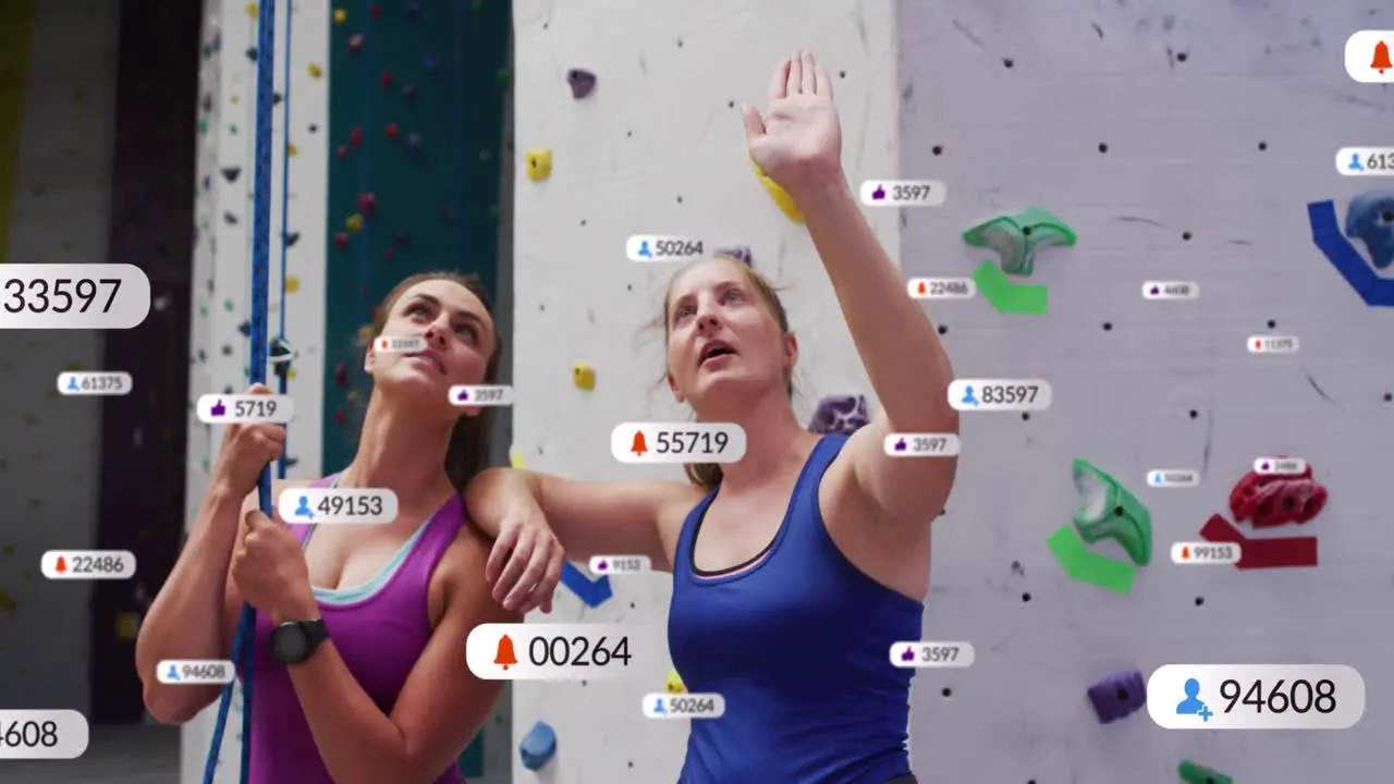 Speech bubbles with digital icons against two caucasian fit women discussing before wall climbing