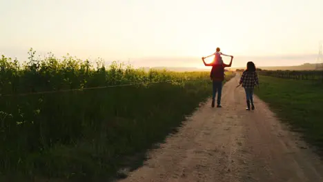 Family walking along a farm at sunset