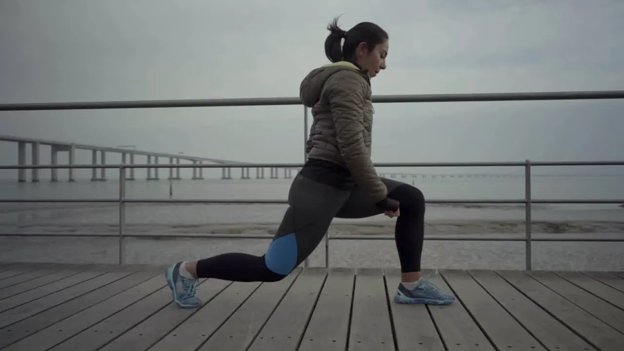 Side view of concentrated hindu woman stretching before workout