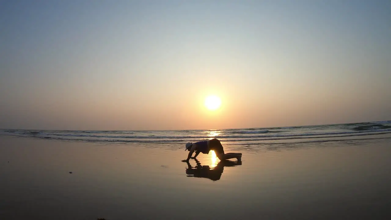 Silhouette of a South Asian Indian Male Running into the Sunset on a Beautiful Beach during Summer Vacation