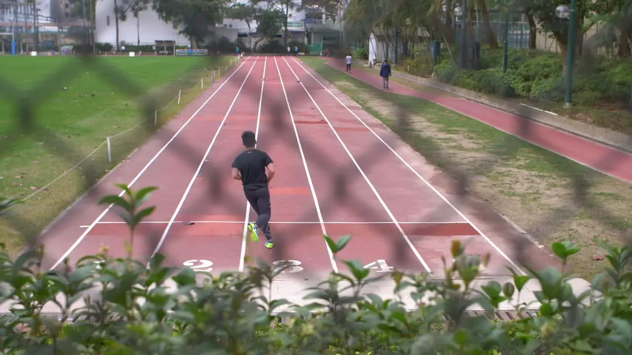 Reveal Shot of Man Running on Track