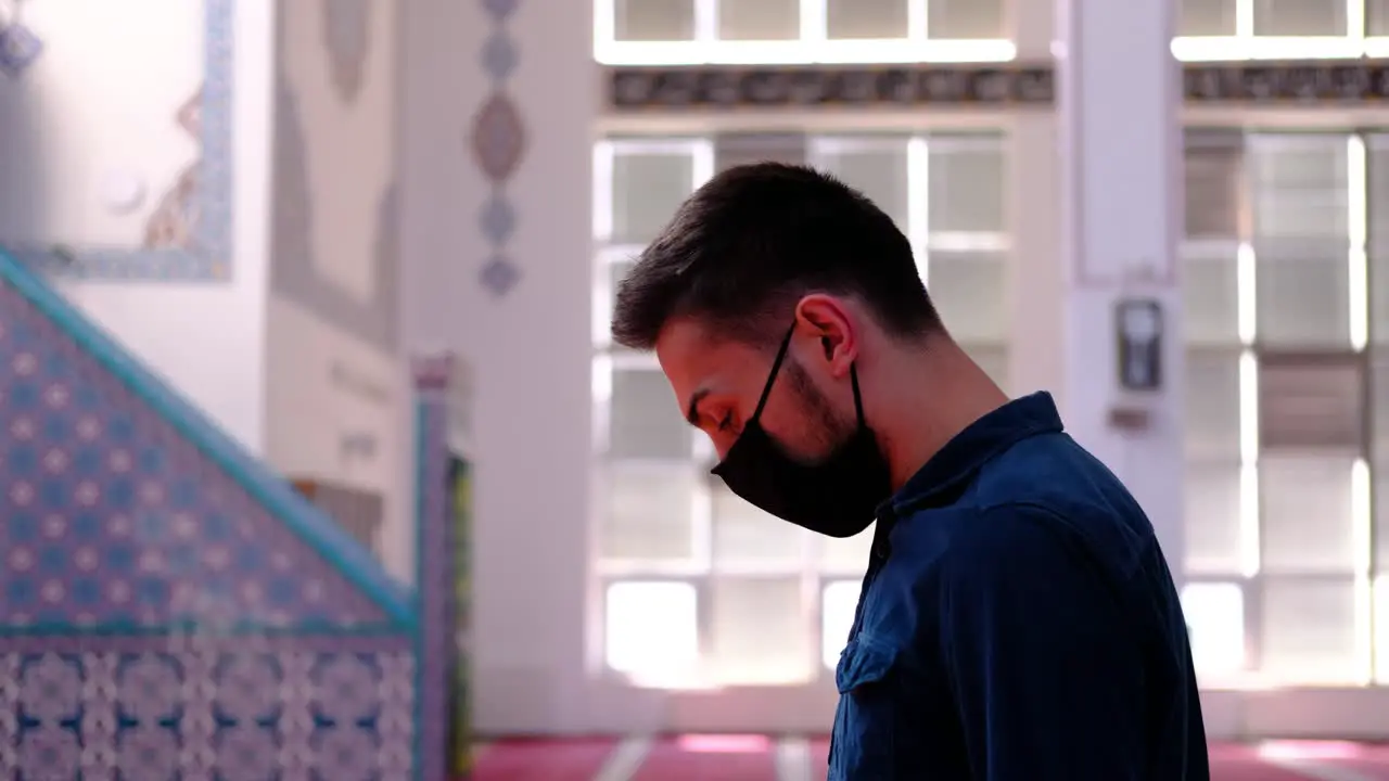 Young Man Worships In A Mask in A Mosque