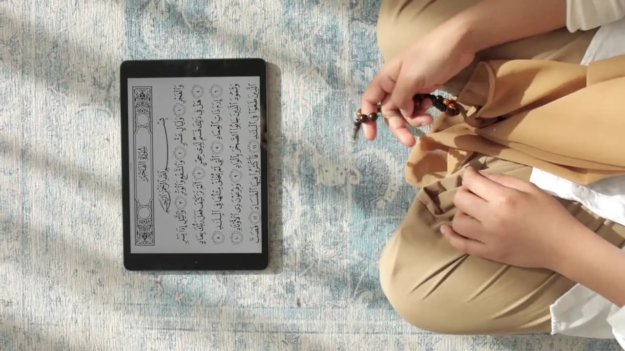 Muslim making Dhikr and reading Quran digitally from tablet