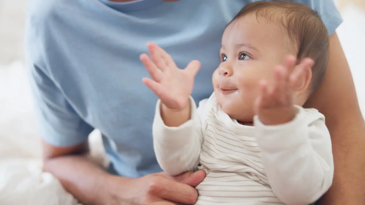 Young infant clapping and bed with parents