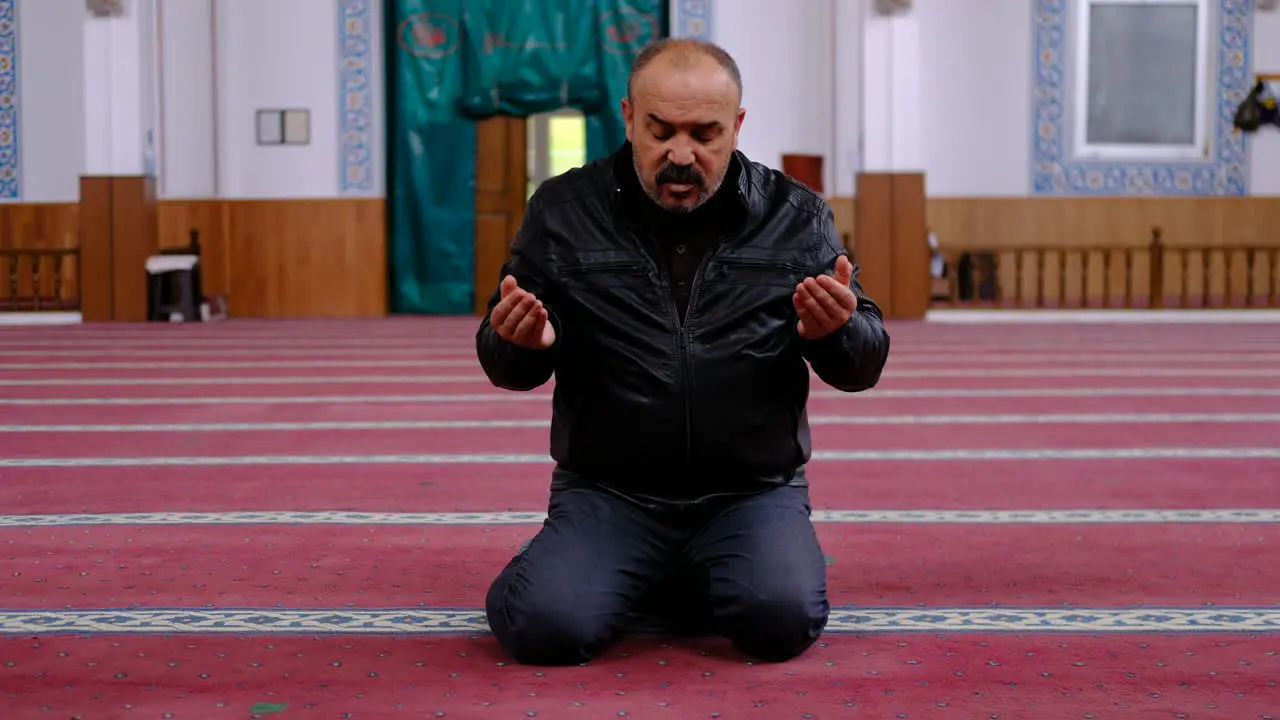 Man Raising His Hands And Praying In Mosque