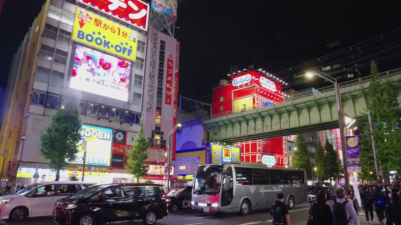 Reveal of Akihabara electric town at night pan from advertisements and neon signs to streets