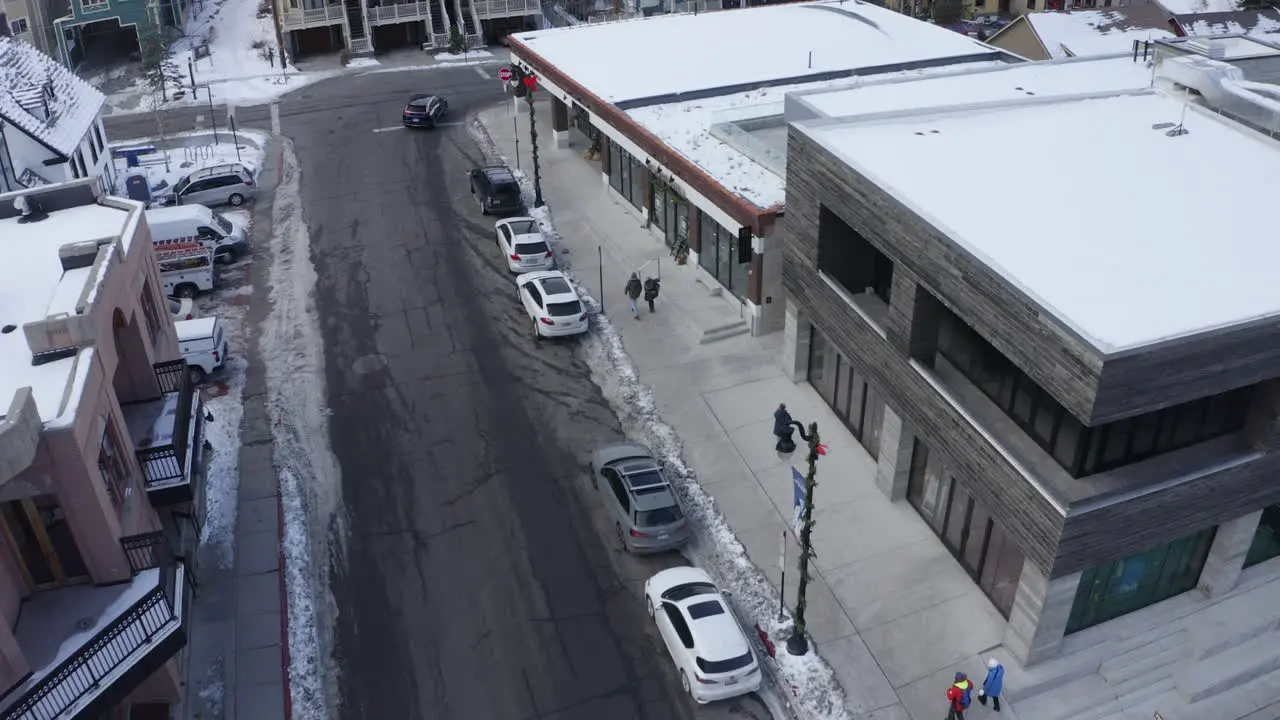 Aerial view of a street through the mountain city in Park City Utah USA with people walking on the sidewalk shopping on a cold wintry evening