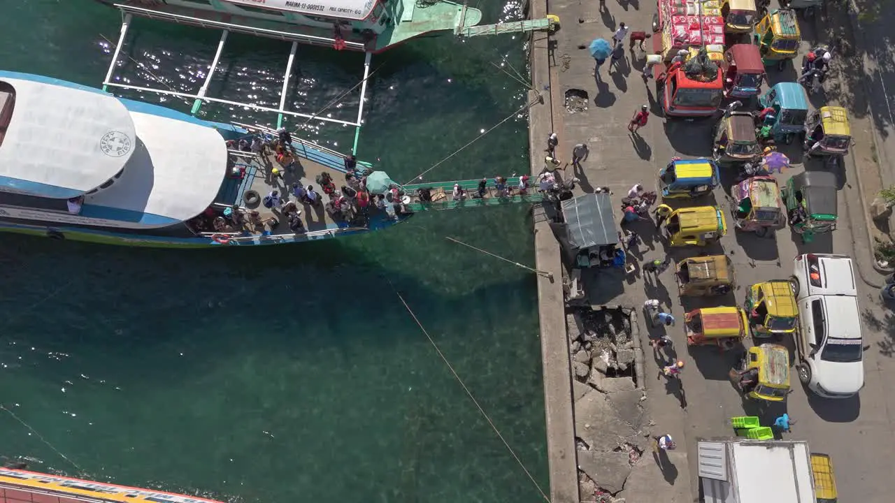 Aerial top down of people offloading from an island hopping commuter boat