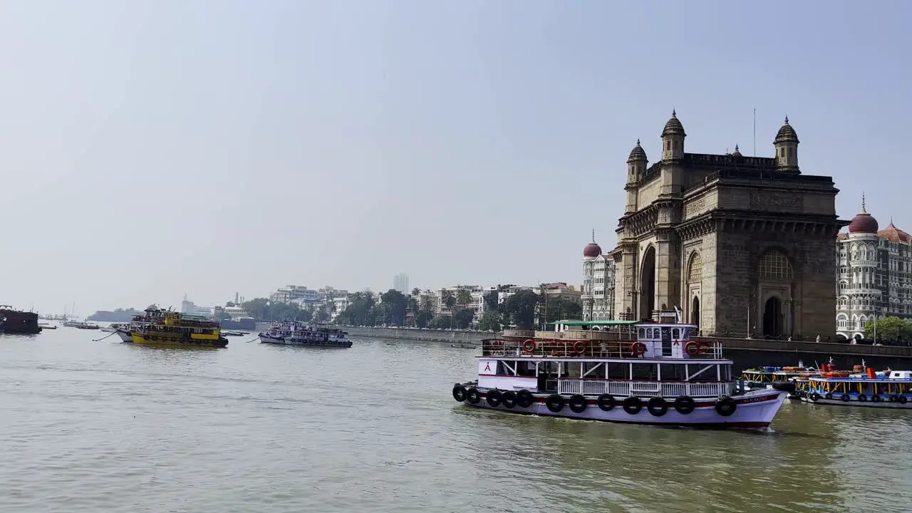 A side angle shot of the historic structure the Gate way of India standing by the Arabian sea in Mumbai