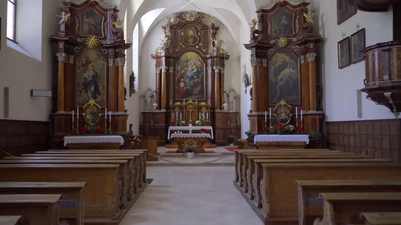 Moving dolly shot of the interior of a 17th century Roman catholic church in San Candido Italy